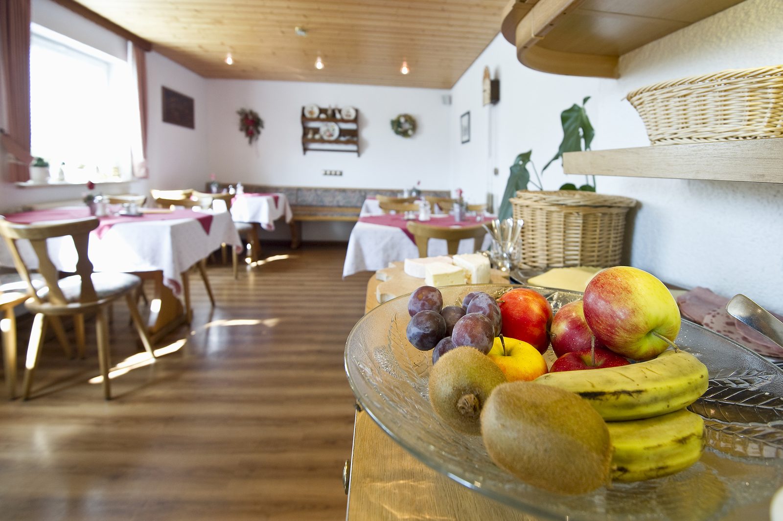 Der separate Frühstücksraum mit gedeckten Tischen und einer Obstschale im Vordergrund